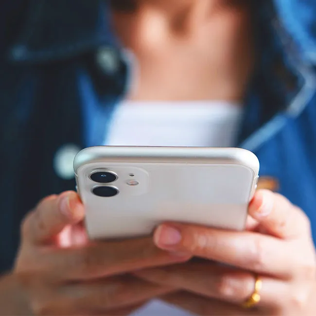 "Woman texting on a white iPhone"