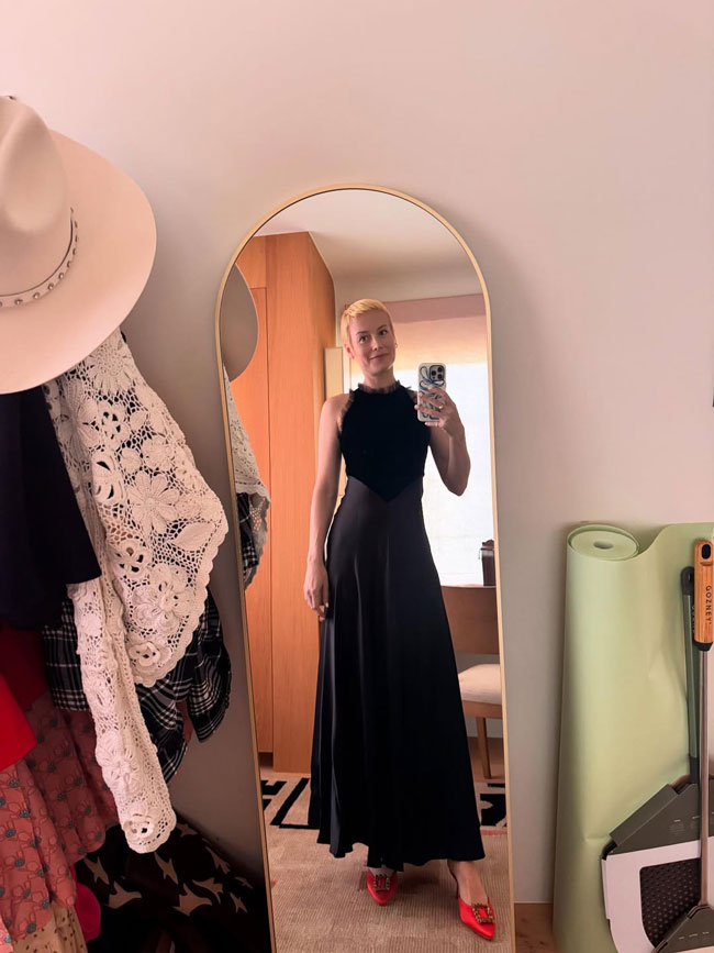 Brie Larson in a stylish black ruffled dress mirror selfie.