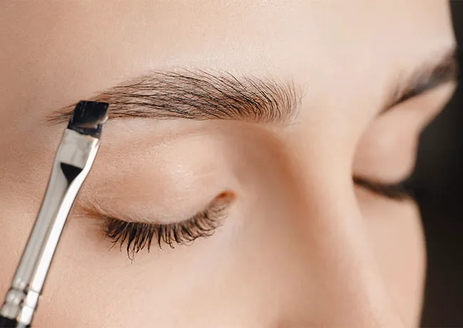 woman-doing-eyebrow-makeup