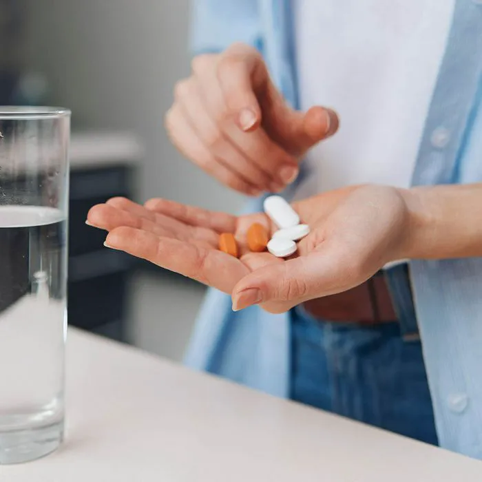 woman taking pills with water