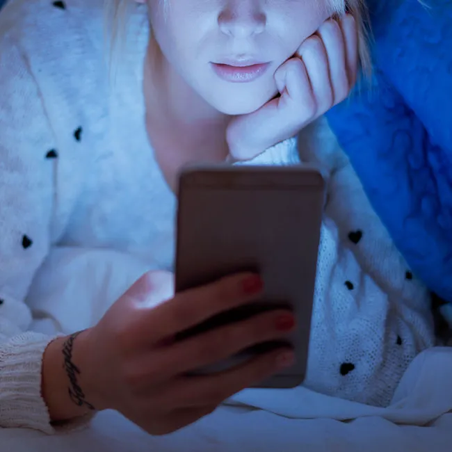 woman-looking-at-phone-bed