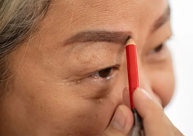 older-woman-drawing-eyebrows