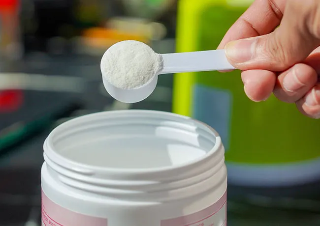 person-scooping-collagen-powder