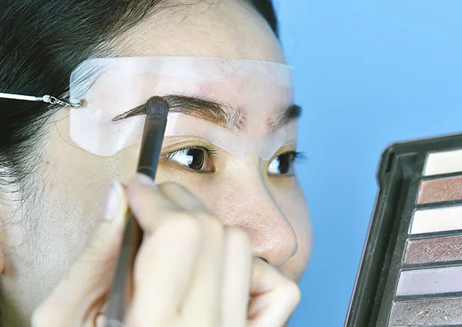 woman-using-eyebrow-stencil
