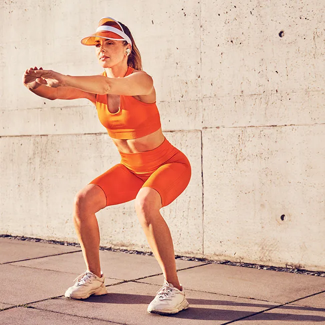 "Woman doing squats during workout"
