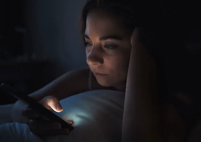 woman-looking-at-phone-bed