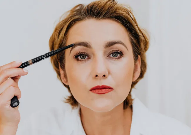woman-penciling-eyebrows
