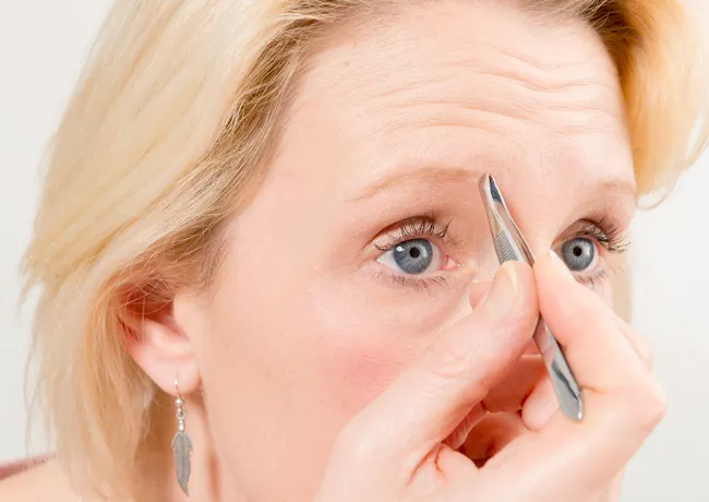 woman-plucking-brows