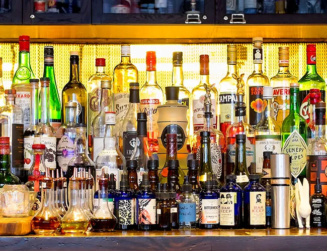Bottles of alcohol displayed behind a bar counter.