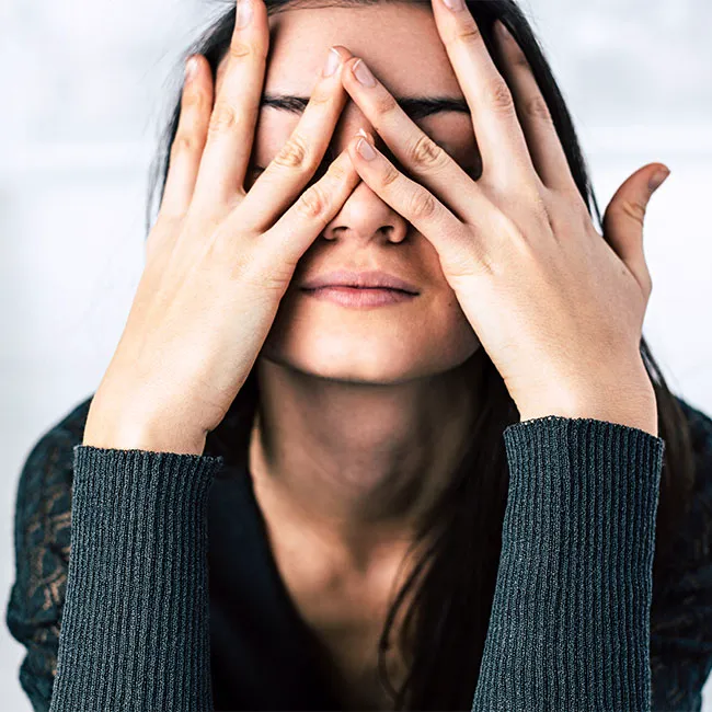 Stressed woman holding her head in frustration.