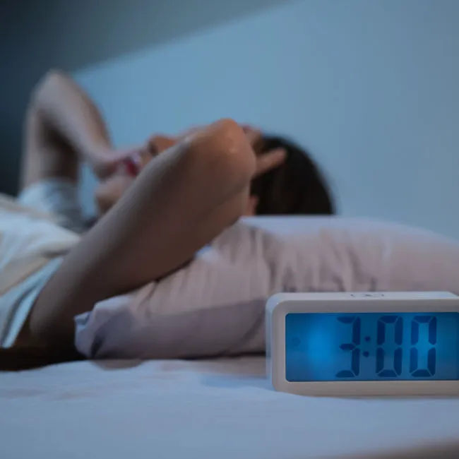 Woman struggling to sleep, overwhelmed by emotions.