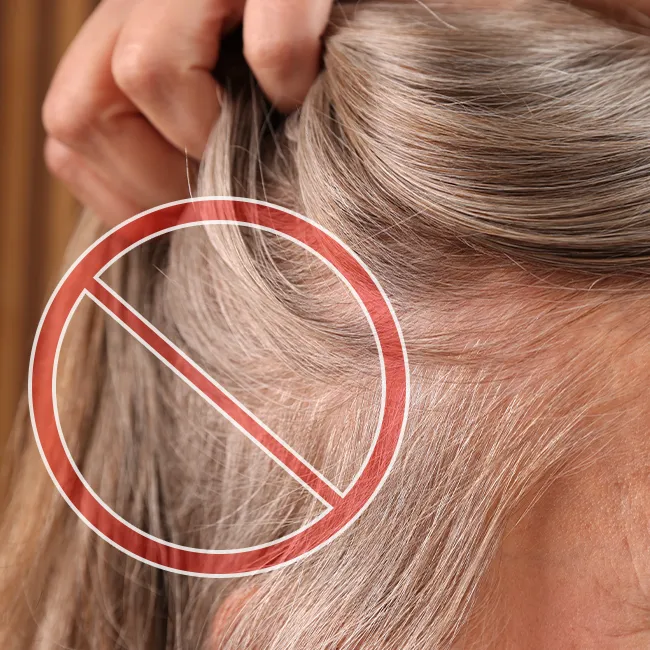 Woman with thinning hair looking in the mirror