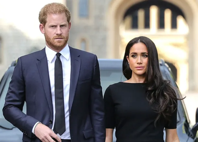 "Prince Harry and Meghan Markle looking at floral tributes for Queen Elizabeth"