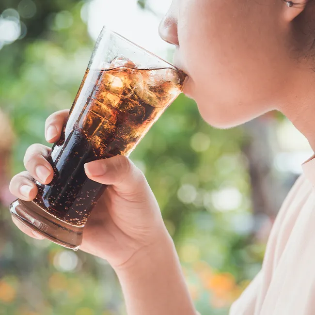 Person drinking soda at a casual gathering.