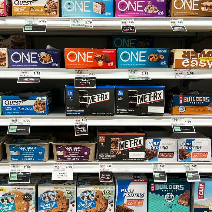 "Various protein energy bars on store shelves"