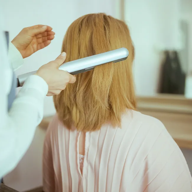 "Woman getting her hair styled in a professional salon"