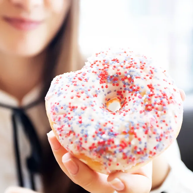Woman enjoying a colorful donut treat.
