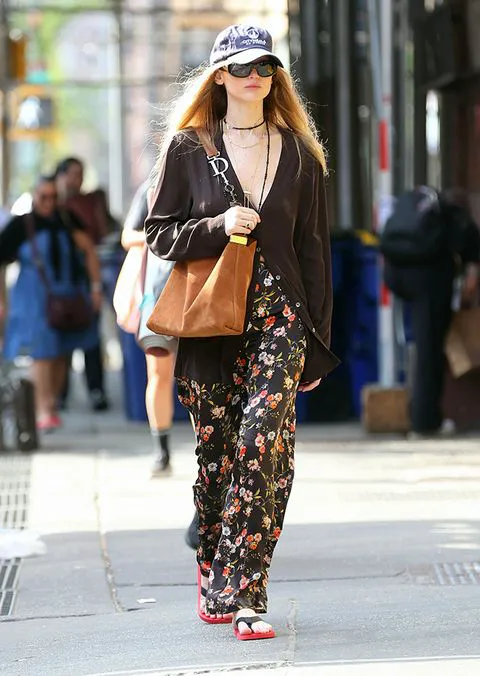 "Jennifer Lawrence in a hat with floral pants and a bag"