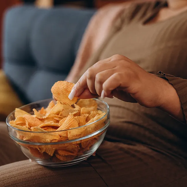 "Woman having chips for a snack"